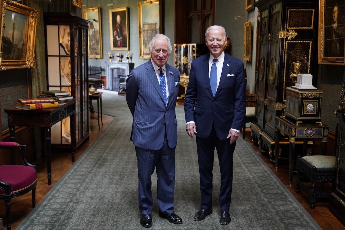 König Charles und Joe Biden posieren im großen Korridor von Schloss Windsor