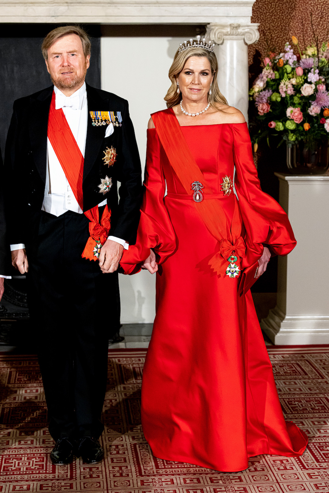 11. April 2023: Das niederländische Königspaar richtet ein Staatsbankett zu Ehren von Präsident Macron aus. Königin Maxima trägt ein rotes Kleid mit Ballonärmeln von Claes Iversen. © Patrick van Katwijk/WireImage
