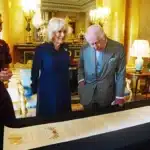 König Charles und Königin Camilla begutachten die Krönugnsrolle