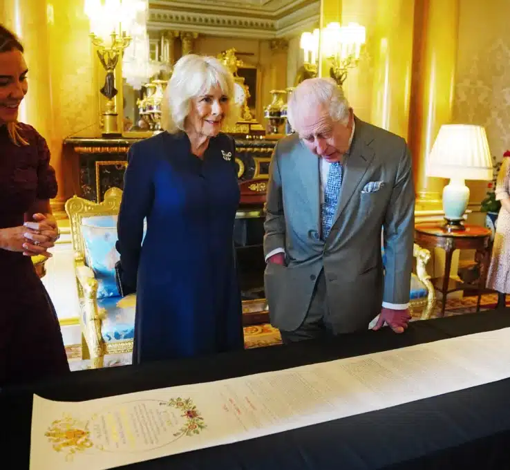 König Charles und Königin Camilla begutachten die Krönugnsrolle